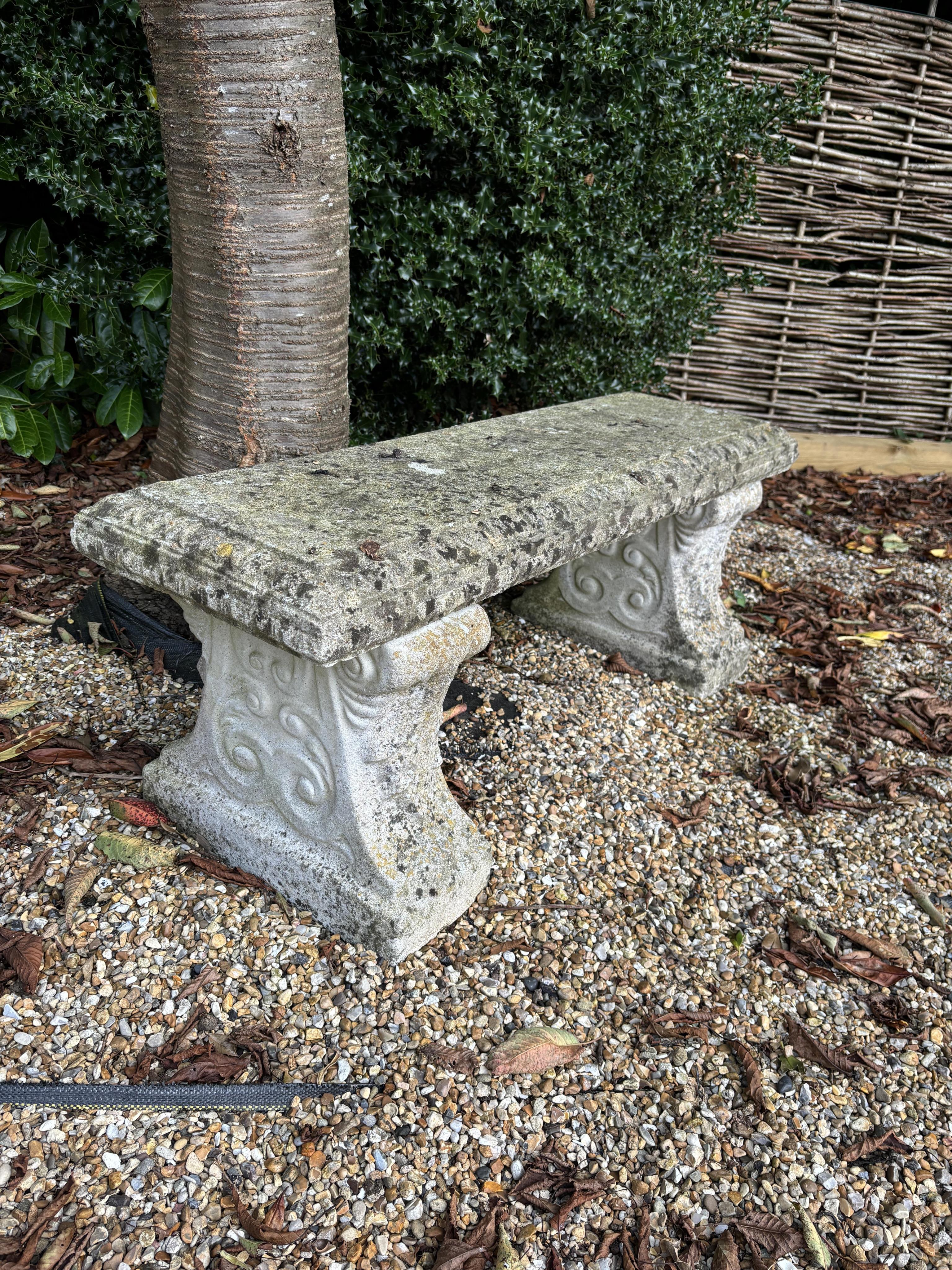 Two reconstituted stone benches, one curved, width 110cm, height 40cm, the other straight, width 114cm, height 44cm. Condition - both weathered, otherwise good condition